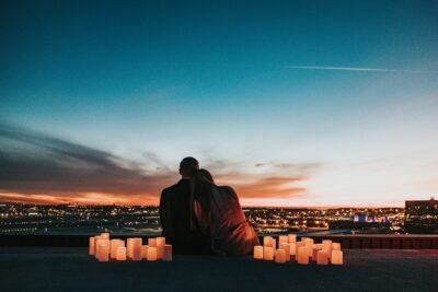 A couple embracing on a balcony overlooking a city, symbolizing the intersection of connection, intimacy, and strategic understanding in both love and business.