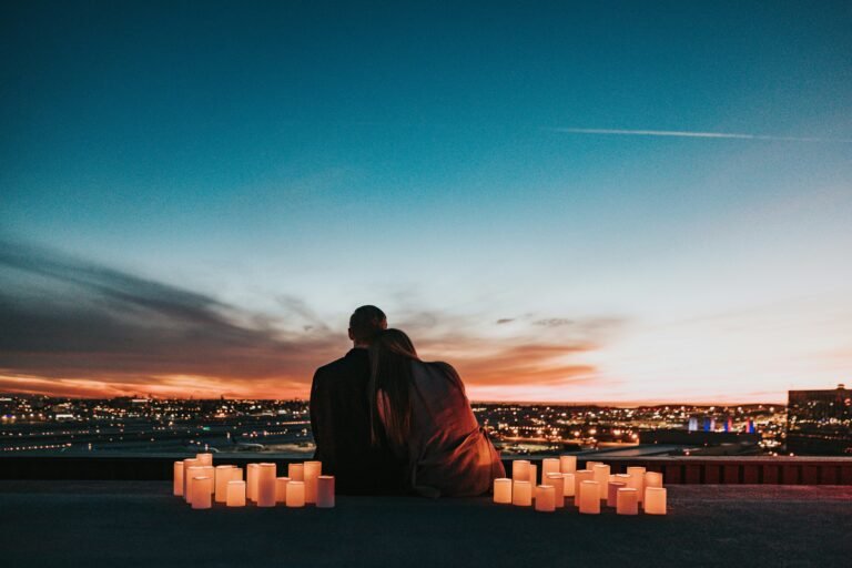 A couple embracing on a balcony overlooking a city, symbolizing the intersection of connection, intimacy, and strategic understanding in both love and business.
